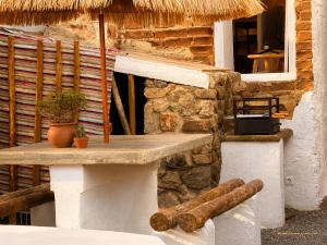 a table in front of a stone building with at Casa do tio Frade in Aldeia do Mato