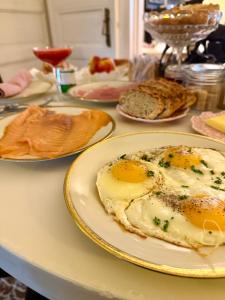 a table topped with plates of eggs and bread at Maison VCB Ciney - Hôtel Particulier de 1820, Cœur de Ville, Parc & Parking Privé in Ciney +50 photos
