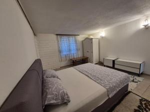 a bedroom with a large bed and a window at Rooms-Zejnep SARAJEVO in Sarajevo