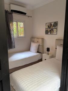 a bedroom with two beds and a window at Riad Lyna in Marrakesh +51 photos