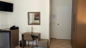 a room with a desk and a mirror on the wall at Anthoussa Rooms in Parga