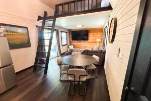 a tiny house with a table and a ladder at Red Barn North - 40 in Mead