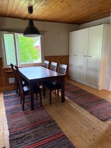 a dining room with a wooden table and chairs at Tamminiemi in Luodonmaa