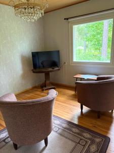 a living room with two chairs and a television at Tamminiemi in Luodonmaa