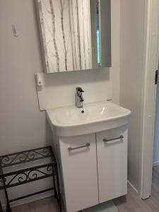 a bathroom with a white sink and a mirror at Tamminiemi in Luodonmaa +8 photos
