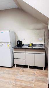 a kitchen with a stove and a white refrigerator at SomosRio II Apart in La Cruz