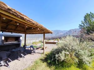a gazebo with chairs and a grill in a field at Miramonte Posada Cacheuta in Ciudad Lujan de Cuyo
