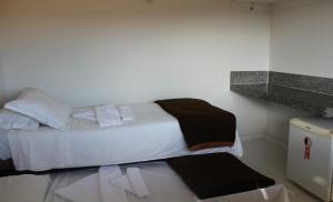a bedroom with a bed with towels on it at Summit Capitólio Hotel in Capitólio