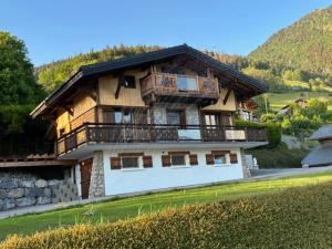 a large house with a balcony on top of it at Nid des aiguillettes in Chevenoz