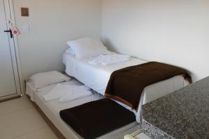 a small room with two beds and a counter at Summit Capitólio Hotel in Capitólio
