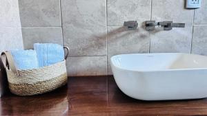 a bathroom with a sink and a basket of towels at SomosRio II Apart in La Cruz