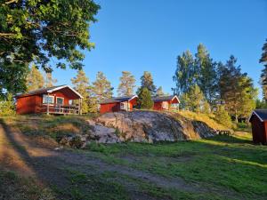 a group of cottages on a hill with trees at Långseruds Stugby Nature Cabins in Byn