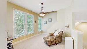 a living room with a chair and large windows at Bear Trap Dunes - 45D Willow Oak Ave in Ocean View