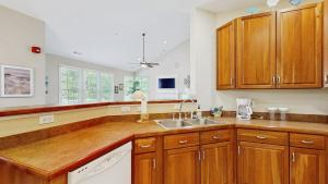 a kitchen with wooden cabinets and a sink at Bear Trap Dunes - 45D Willow Oak Ave in Ocean View