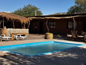 a swimming pool in front of a house at Hotel Pat'ta Hoiri in San Pedro de Atacama