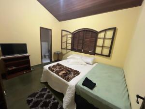 a bedroom with a large bed and a television at Sítio do vô Hélio - Petropolis in Araras Petropolis +82 photos