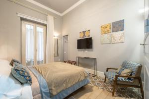 a bedroom with a bed and a chair and a tv at Guest House 73 in Cagliari