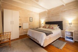 a bedroom with a large bed and wooden walls at Big Sky Cottages in Wolseley +59 photos