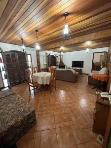 a living room with wooden ceilings and a table and chairs at Sítio do vô Hélio - Petropolis in Araras Petropolis