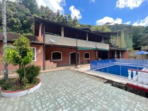 a house with a swimming pool in front of it at Sítio do vô Hélio - Petropolis in Araras Petropolis