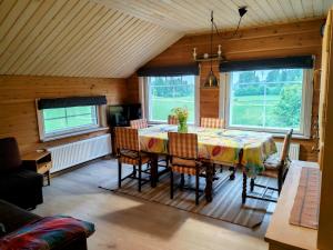 a dining room with a table and some windows at Villa Tuomiranta in Porvoo