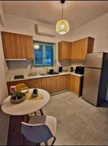 a kitchen with a table and a refrigerator at Ελαιόλιθοι Μάνη Villas 2 in Oitylo