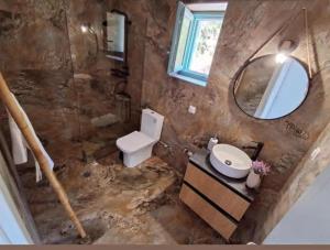 a bathroom with a toilet and a sink and a mirror at Ελαιόλιθοι Μάνη Villas 2 in Oitylo +2 photos