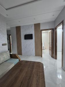 a living room with a couch and a tv on a wall at Calm and facinating vacation in Saïdia