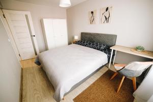 a small bedroom with a bed and a desk at LK Darzu Apartment in Rēzekne