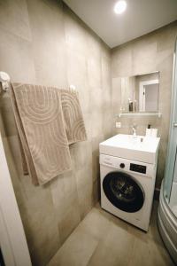 a bathroom with a washing machine and a sink at LK Darzu Apartment in Rēzekne +25 photos