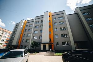 a building with cars parked in front of it at LK Darzu Apartment in Rēzekne
