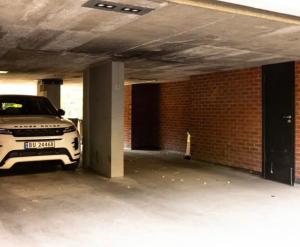 a white car parked in a parking garage at The Frogner Park Townhouse with 2 garages in Oslo