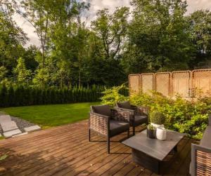 a wooden deck with two chairs and a table at The Frogner Park Townhouse with 2 garages in Oslo