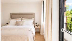 a white bedroom with a bed and a window at The Frogner Park Townhouse with 2 garages in Oslo +32 photos