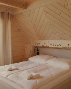 a bed in a room with a wooden ceiling at Lovelia Luxury Chalet & Jacuzzi in Zakopane