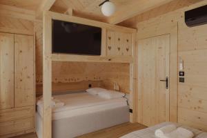 a small bedroom with a bed in a wooden cabin at Lovelia Luxury Chalet & Jacuzzi in Zakopane