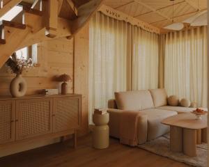 a living room with a couch and a table at Lovelia Luxury Chalet & Jacuzzi in Zakopane