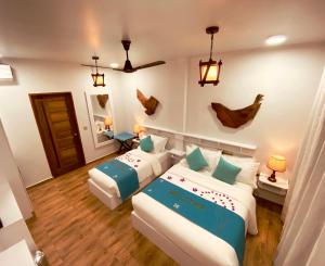 a hotel room with two beds and two lamps at Island Luxury Dive Hotel - Fulhadhoo in Fulhadhoo +53 photos