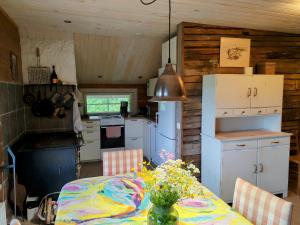 a kitchen and dining room with a table with flowers at Villa Tuomiranta in Porvoo +40 photos
