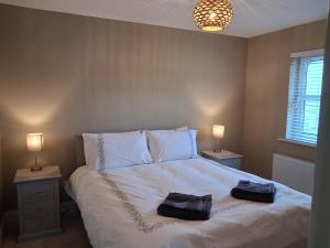 a bedroom with a bed with two towels on it at 56 Woodlands in Clonakilty