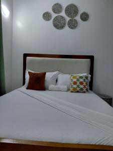 a bed with white sheets and pillows on it at Havy Homes in Bamburi