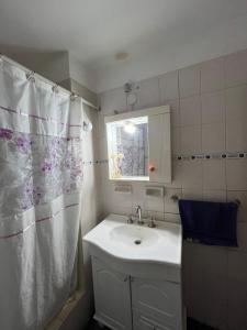 a bathroom with a sink and a shower curtain at La Casa del Barrio in Ramallo +33 photos