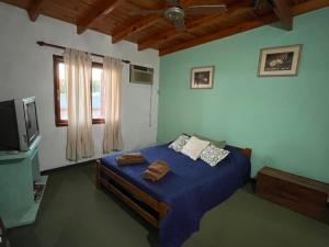 a bedroom with a blue bed and a television at La Casa del Barrio in Ramallo