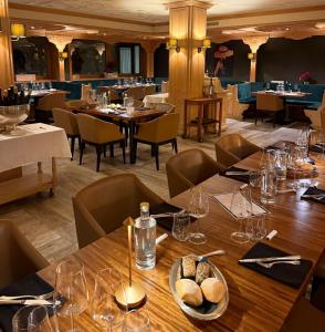 a dining room with tables and chairs in a restaurant at Grifone Dolomiti Resort in Arabba