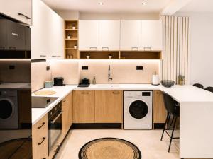 a kitchen with white cabinets and a washer and dryer at Aura di centro Thassos in Limenas
