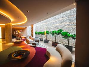 a living room with a large window with plants at Mercure Camboriu in Balneário Camboriú