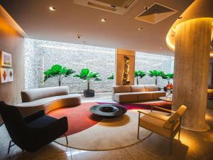 a living room with couches and a table and chairs at Mercure Camboriu in Balneário Camboriú