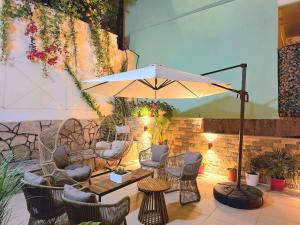 a patio with a table and chairs and an umbrella at Villa Meminaj in Vlorë