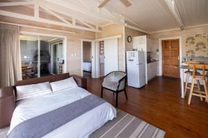 a bedroom with a bed and a kitchen with a table at Big Sky Cottages in Wolseley