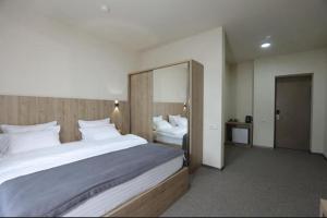 a bedroom with a large bed and a large mirror at Aleksberg Club, Dilijan Hotel in Dilijan